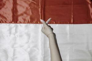 mains faire des gestes l'amour signe par les doigts isolé par indonésien rouge et blanc drapeau. l'indonésie indépendance journée concept photo