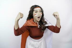 excité asiatique femme portant une rouge haut, drapeau cap et Bandeau, montrant fort geste par levage sa bras et muscles souriant fièrement. l'indonésie indépendance journée concept. photo