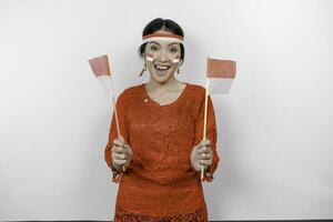 content souriant indonésien femme portant rouge kebaya et Bandeau en portant l'indonésie drapeau à célébrer Indonésie indépendance journée isolé plus de blanc Contexte. photo