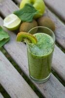 une vert smoothie avec kiwi et Pomme sur une en bois table photo