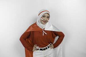 content souriant indonésien musulman femme portant rouge Haut et blanc hijab en portant l'indonésie drapeau à célébrer Indonésie indépendance journée. isolé par blanc Contexte. photo
