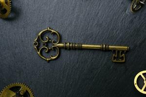 vieux ancien clé et métal engrenages foncé Contexte. photo
