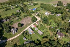 panoramique aérien vue de éco village avec en bois Maisons, gravier route, jardins et vergers photo