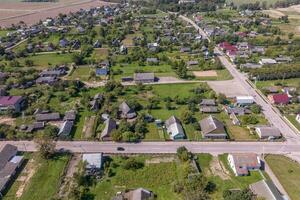 panoramique aérien vue de éco village avec en bois Maisons, gravier route, jardins et vergers photo