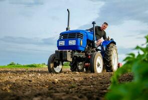 une agriculteur sur une tracteur travaux dans le champ. fraisage sol, écrasement et relâchement sol avant Coupe Lignes. agriculture, agriculture. préparatoire terrassement avant plantation une Nouveau culture. terre cultivation photo