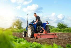 une agriculteur sur une tracteur travaux dans le champ. fraisage sol, écrasement et relâchement sol. travail comme une agriculteur. agriculture. préparatoire terrassements. agriculture secteur agroalimentaire photo