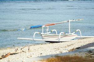 une blanc balinais traditionnel bateau sur le plage dans Nusa Penida photo