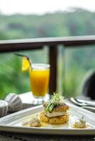 une assiette de nourriture sur une table avec une verre de Orange jus photo