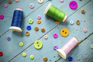 coloré boutons et bobines de fil sur une en bois table photo