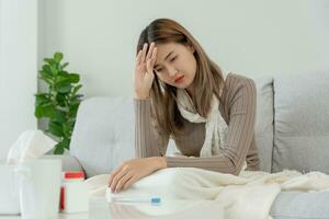 malade femme avec une mal de crâne et sentiment du froid sur canapé, femelle éternuements et qui coule nez avec saisonnier grippe, allergique, haute fièvre et grippe, repos, virus, corona virus, ressentir maladie, respiratoire photo