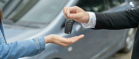 louer, louer une voiture, vendre, acheter. le directeur de la concession envoie les clés de la voiture au nouveau propriétaire. vente, pret credit financier, location vehicule, assurance, location, vendeur, concessionnaire, mensualite, entreprise d'entretien automobile photo