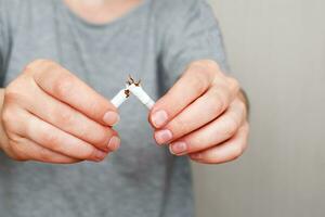 jeune femme tenant une cigarette cassée dans ses mains à proximité photo