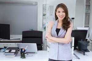 professionnel Jeune asiatique affaires femme Bureau ouvrier dans gris chemise est souriant travail réussi en toute confiance avec bras franchi dans le Bureau chambre. photo