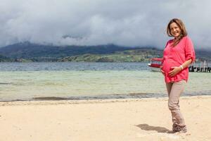 portrait de une Jeune femme attendre pour sa bébé à le magnifique blanc plage de Lac tout à fait situé dans le département de boyaca à 3 015 mètres au dessus mer niveau dans Colombie photo