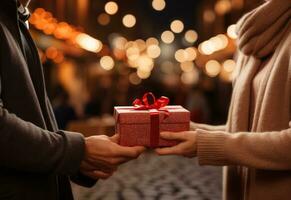 une femme mains en dehors une rouge cadeau à une homme photo