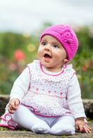 sucré six mois vieux bébé fille séance à le jardin dans une magnifique ensoleillé journée photo