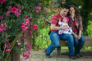 Jeune Parents ayant amusement en plein air avec leur six mois vieux bébé fille. bonheur concept. famille concept photo