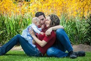 Jeune Parents ayant amusement en plein air avec leur six mois vieux bébé fille. bonheur concept. famille concept photo