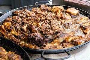 Viande Ragoût avec bœuf, porc et agneau dans une juteux sauce bouillonnant dans une grand la poêle dans le rue marché. photo