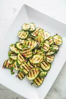 courgette. grillé Zucchini avec rouge pimenter sur blanc assiette photo