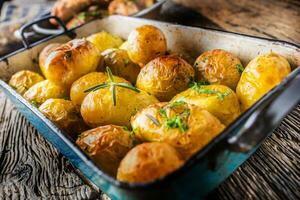 rôti patates avec herbes dans la poêle sur rustique chêne table photo