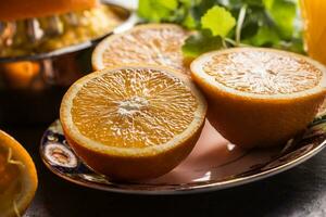 Frais des oranges presse-agrumes jus tropical des fruits et herbes sur béton planche photo