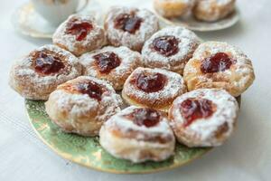 une assiette de beignets rempli avec confiture et recouvert dans sucre photo