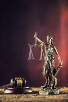 Dame Justicia en portant épée et échelle bronze figurine avec juge marteau sur en bois table photo