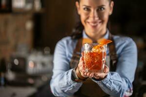 vieux façonné boisson dans ornemental verre offert par une femelle barman dans une pub photo
