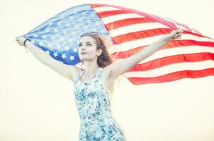 Jeune content américain femme en portant Etats-Unis drapeau photo