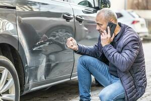 un en colère chauffeur appels le Assurance entreprise ou le police car de une endommagé voiture photo