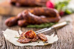 saucisses. fumé saucisses. chorizo saucisses avec légume Romarin épices et cuisine ustensile. photo