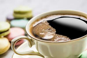 tasse de noir café avec français macarons photo