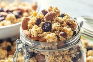 pot de muesli avec des noisettes, amandes les raisins et séché des fruits - fermer photo