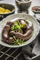 rôti saucisses dans la poêle avec Romarin. traditionnel européen nourriture bratwurst jaternice ou jirnice photo