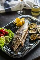 rôti poisson sur plat avec Frais et grillé légume photo