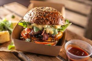 savoureux fait maison Burger à emporter dans une boîte de recyclé papier sur en bois planches photo