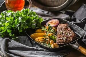 du boeuf flanc steak dans gril la poêle avec batata purée Ail herbe décoration et Brouillon Bière photo