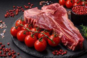 brut Frais juteux du boeuf t-bone steak avec sel, épices et herbes photo