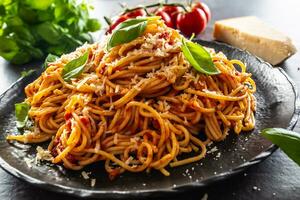 Pâtes spaghetti tomates et bolognaise sauce avec huile pétrole Parmesan et basilic photo