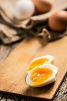 fermer bouilli ou brut poulet des œufs sur en bois planche photo