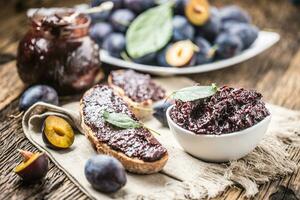 petit déjeuner de fait maison prune confiture pain et mûr prunes. photo