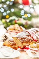 traditionnel tchèque Noël gâteau vanocka sur une de fête table dans de face de une Noël arbre photo