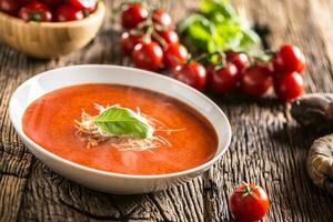 chaud tomate soupe Parmesan fromage et basilic laisser sur vieux oal table photo