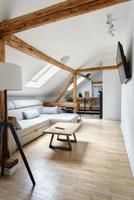 appartement mansardé, salon moderne, design d'intérieur d'appartement avec de vieilles poutres en bois rustiques, sols et meubles. photo