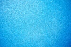 abstrait lumière bleu stuc Contexte. mur bâtiment proche en haut. rugueux surface plâtre texture avec copie espace pour conception photo