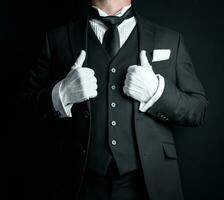 portrait de sur de soi majordome dans foncé formel costume et blanc gants désireux à être de service. professionnel courtoisie et hospitalité. photo