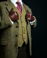 portrait de gentilhomme dans tweed costume et cuir gants permanent élégamment. ancien style et rétro mode de Anglais gentilhomme. photo