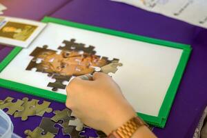 thaïlandais élèves créer scie sauteuse puzzles de important scientifiques dans le science apprentissage base sur la Thaïlande nationale science journée. doux et sélectif se concentrer. photo