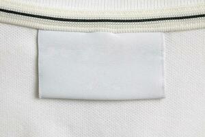 Vide blanc blanchisserie se soucier vêtements étiquette sur blanc chemise en tissu texture Contexte photo